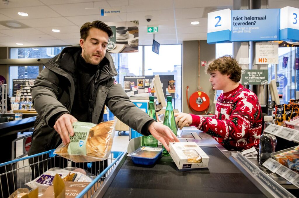 person interacting with cashier at dutch supermarket person interacting with cashier at Amsterdam's local supermarket in Dutch
